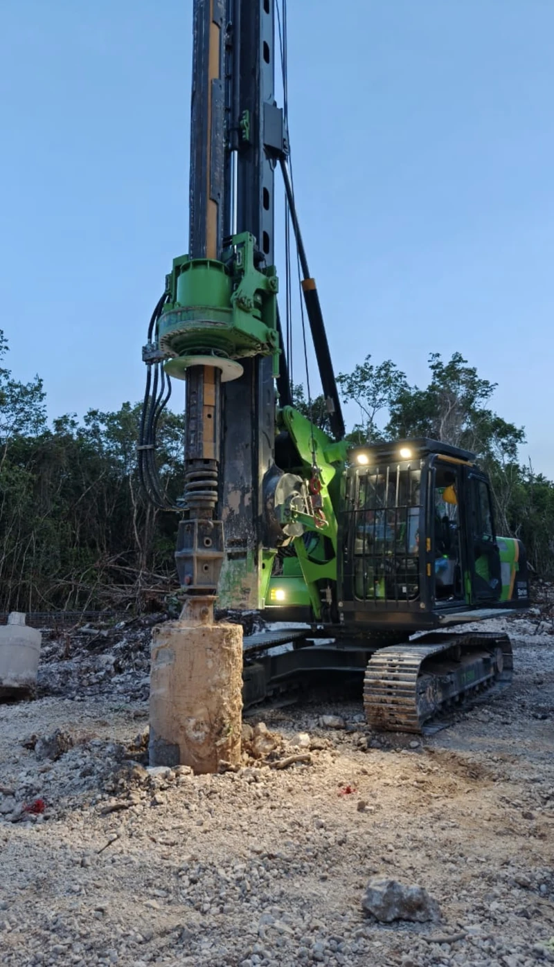Garra de Jaguar · perforadora verde al atardecer con luces de trabajo encendidas